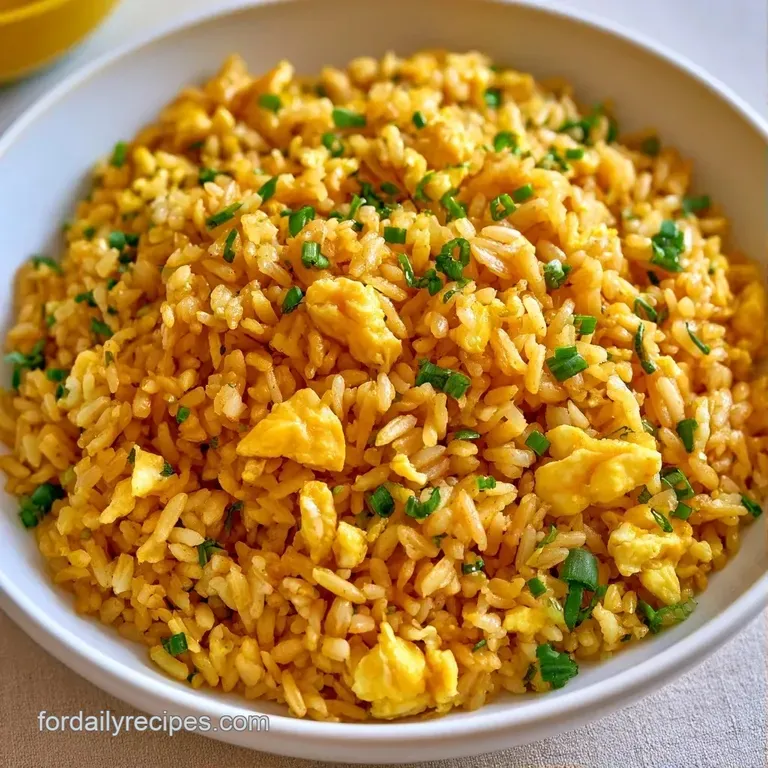 Bright yellow scrambled egg curds artfully piled high on a white plate, topped with fresh sliced scallions.