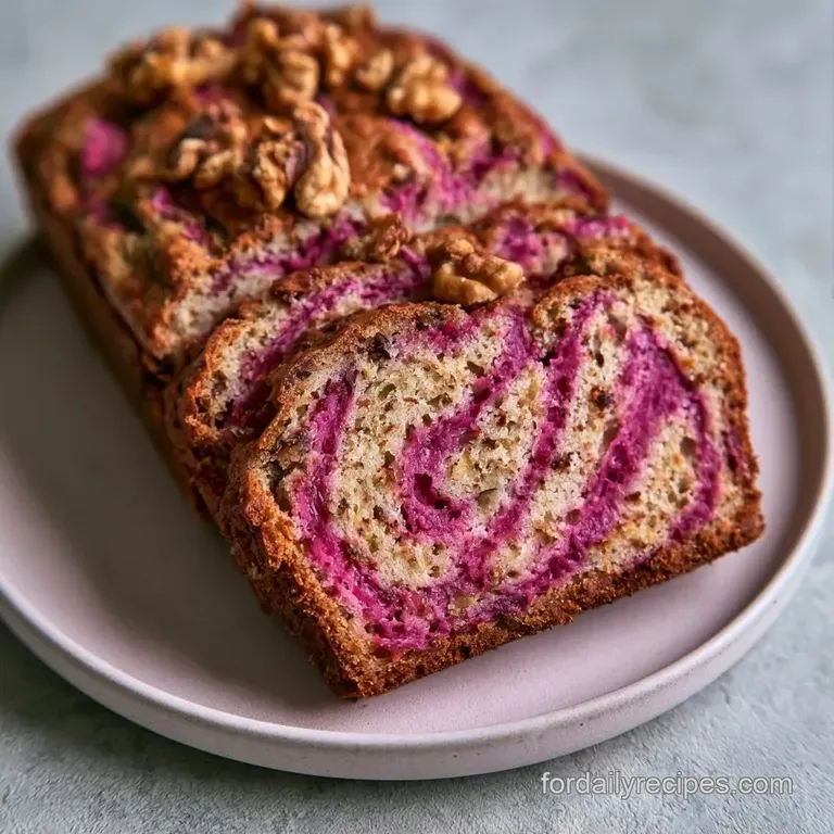 A thick slice of moist cake with pink rhubarb ribbons and crunchy walnuts on a white ceramic plate with a linen napkin.